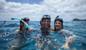 three women laughing in water wearing mask and snorkel