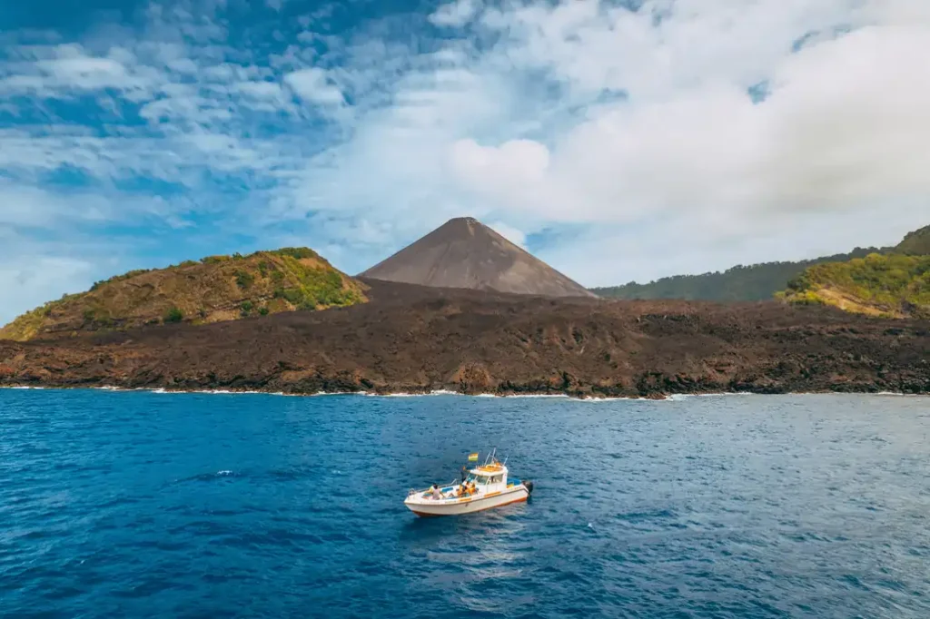 A boat in front of Barren Island volcano